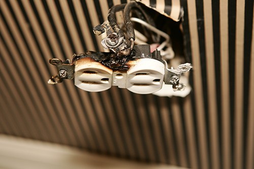 A burned electrical outlet hanging